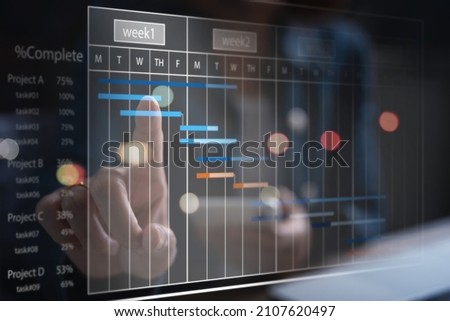 Project manager working and update tasks with milestones progress planning. Businessman using laptop computer and digital tablet with Gantt chart scheduling virtual diagram, project management concept Royalty-Free Stock Photo #2107620497