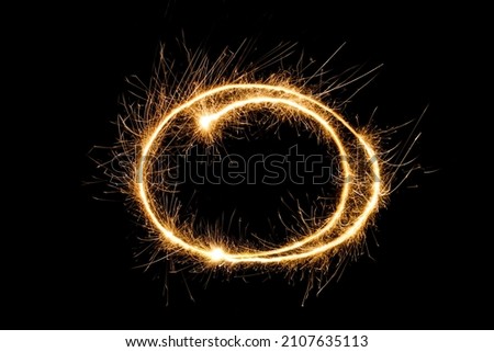 Burning Sparkling round frame isolated on black background. Beautiful Glowing design element for greeting card, holiday flyer