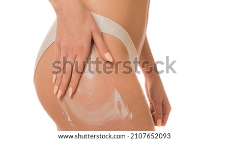 Body care. Woman applying cream on legs and buttocks. Female applying anti cellulite cream