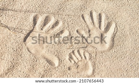 handprints in the sand on the beach of the Baltic Sea. Connectedness of a family with father, mother and child. Symbol of togetherness for eternity