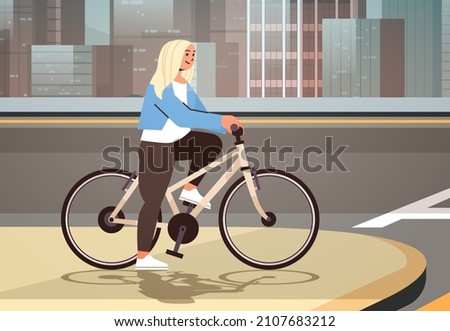 young woman cyclist waiting for green traffic light to cross road on crosswalk girl riding bicycle healthy lifestyle