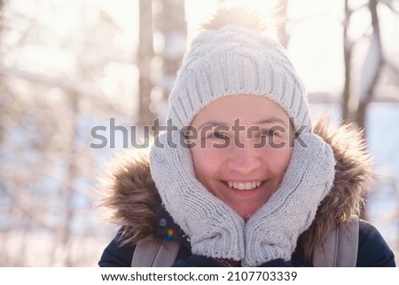 Happy Asian woman walking in winter snow forest. Cold weather hat and warm coat. idea and concept of healthy active lifestyle and good mood in any weather