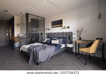Modern, open plan studio apartment with big, cozy bed and shower behind glass wall Royalty-Free Stock Photo #2107706372