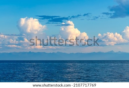 Cumulus clouds above lake Baikal in Siberia. Royalty-Free Stock Photo #2107717769