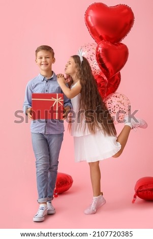 Happy children with gift and balloons on color background. Valentine's Day celebration
