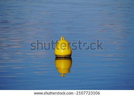 Yellow buoy on blue water surface	