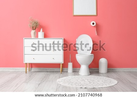 Interior of stylish modern restroom with pink wall