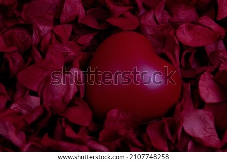 Red Heart on red background, bedded with Red Rose Petals