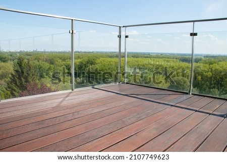Contemporary architecture appartment balcony view with exotic cumaru wood grooved decking and glass railing Royalty-Free Stock Photo #2107749623