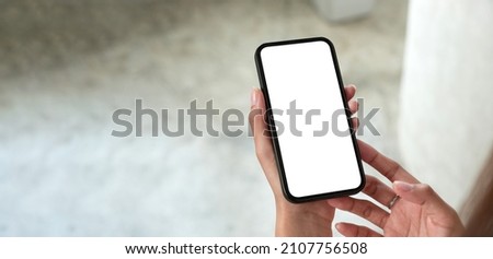 Top view of mock up phone in woman hand showing white screen