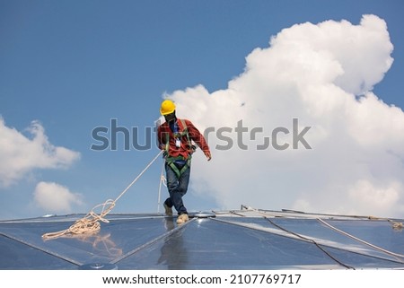 Male workers rope access height safety connecting with a knot safety harness, roof fall arrest and fall restraint anchor point systems ready to ascending, construction site oil tank dome Royalty-Free Stock Photo #2107769717