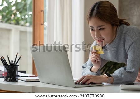 Close up image of a happy woman holding credit card while using laptop computer. online shopping with cash back, discount sales, low prices, saving money. Money back concept.