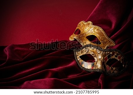 Luxury venetian mask on dark red background. Carnival masquerade fantasy mask Royalty-Free Stock Photo #2107785995