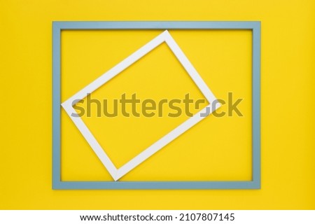 White frame rotated in a light blue frame on a vibrant yellow background