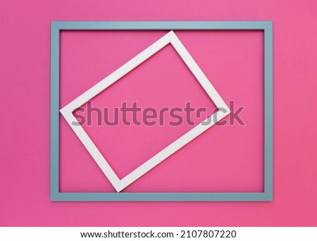 White frame rotated in a light blue frame on a vibrant pink background