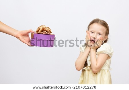 Adorable little surprise girl with purple gift box present on background