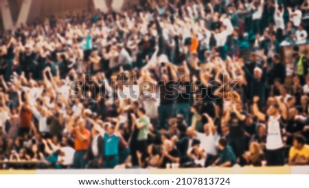 crowd cheering at sports event blurred photo