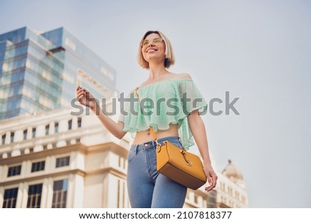 Low angle view photo of young attractive girl happy positive smile walk city trip handbag summer outdoors