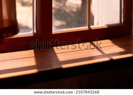 sunlight shining through the window and shadows on the wooden windowsill Royalty-Free Stock Photo #2107843268