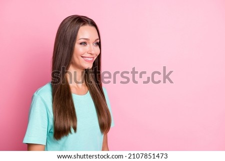 Photo portrait of beautiful girl in blue outfit smiling happy looking empty space isolated on pastel pink color background