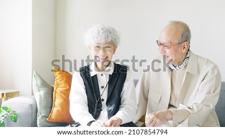Asian elderly couple talking in the room. Royalty-Free Stock Photo #2107854794