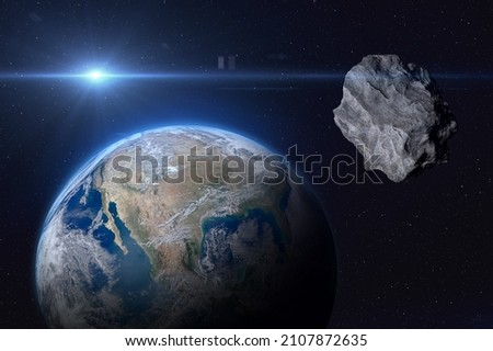 Planet Earth and big asteroid in the space. Potentially hazardous asteroids (PHAs). Asteroid in outer space near Earth planet. Elements of this image furnished by NASA.  Royalty-Free Stock Photo #2107872635