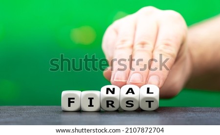 Hand turns dice and changes the word "first" to "final". Royalty-Free Stock Photo #2107872704