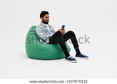 Young man sitting comfy soft violet armchair holding telephone chatting colleagues wear specs casual denim outfit isolated grey color background Royalty-Free Stock Photo #2107879232