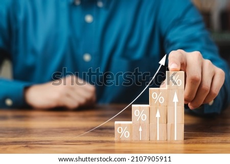 Interest rate and dividend concept, wooden block with percentage symbol and up arrow, return on stocks and mutual funds, long term investment for retirement. Royalty-Free Stock Photo #2107905911