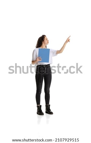 Portrait of young girl, worker pointing upwards isolated over white background. Presentation and discussion of project. Concept of work, education, career, growth, motivation and ad