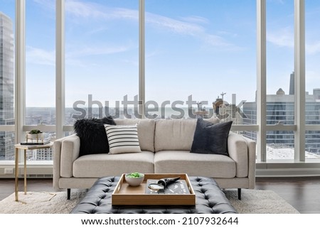 Stylish Penthouse Living Room with Skyline Views of City and Lakefront Royalty-Free Stock Photo #2107932644