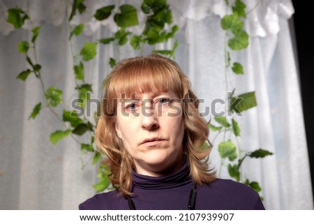 An inept photo of an ordinary girl. A middle-aged woman in an indoor studio. A picture of a selfie or novice photographer