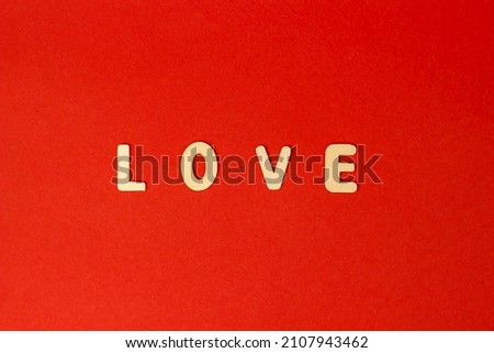 inscription love from wooden letters on a red background. February 14 and Valentine's Day. Love and relationships concept. Romance and recognition.