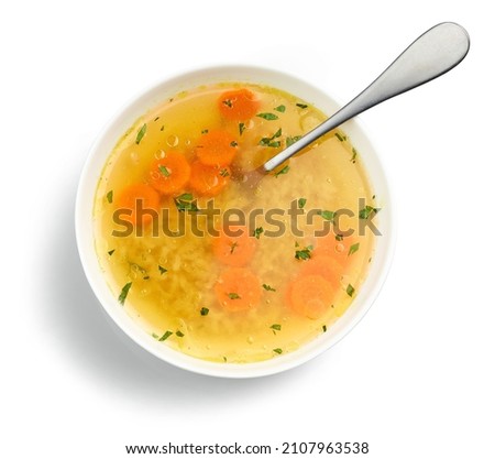 bowl of chicken broth soup with vegetables and rice isolated on white background, top view