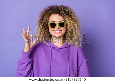 Photo of cool funny lady dressed hoodie arm dark eyewear showing okey signs isolated purple color background