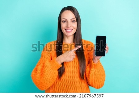 Photo of impressed young brunette lady index telephone wear orange pullover isolated on teal color background