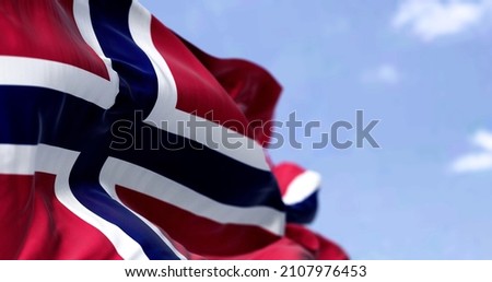 Detail of the national flag of Norway waving in the wind on a clear day. Democracy and politics. North European country. Selective focus. Royalty-Free Stock Photo #2107976453