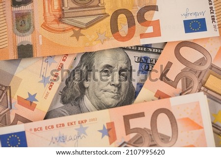 Closeup view of one hundred dollars banknote with euro money banknotes around as financial background. Cash money. Financial growth and business concept. Money background Royalty-Free Stock Photo #2107995620