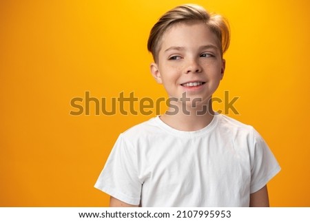 Teenager boy thinking looking away isolated on yellow background