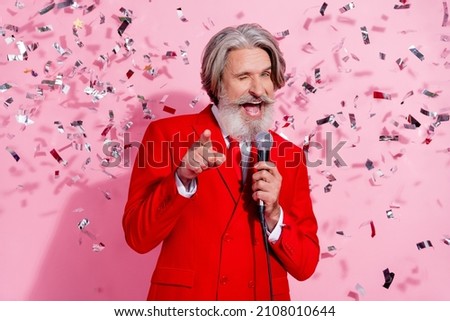 Portrait of attractive cheerful cool trendy grey-haired man mc singing song winking anniversary isolated over pink pastel color background Royalty-Free Stock Photo #2108010644