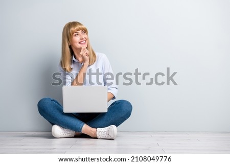 Photo of shiny dreamy lady dressed white shirt working modern gadget looking empty space isolated concrete grey wall background