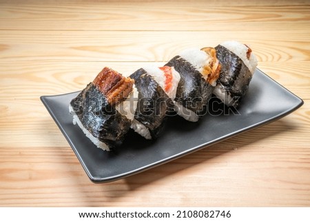 Onigiri or Japanese seaweed rice triangles shaped Stuffed with grilled eel, scallop, plum and fish roe, Japanese Rice Balls  famous food. Royalty-Free Stock Photo #2108082746