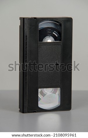 Old analog tape VHS video cassette in studio against white background. Nostalgia retro. Vintage gone down in history.