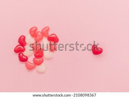 Romantic symbol. Top view photo with copy space. Many colorful candies in heart shape on pink backdrop