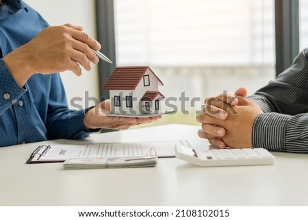 Real estate ideas, selling a house, or renting out real estate. The sales representative discusses the terms of the home sales contract for the customer to sign the legal contract document,