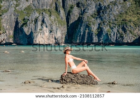 Portrait of asian woman tourist in swimsuit sightseeing and enjoying on the white sand Maya Bay beach and turquoise water, Phi Phi island, Thailand