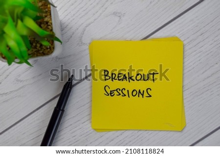 Breakout Sessions write on sticky notes isolated on Wooden Table.