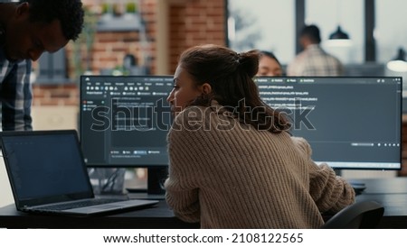 Software programer putting laptop with source code on colleague coder desk asking for opinion about database. Developer writing algorithm interrupted by coworker wanting help with fixing errors. Royalty-Free Stock Photo #2108122565