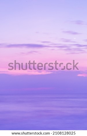 Beautiful long exposure seascape of smooth wavy sea and clound. Pink horizon with first sunset sky. verical photo.