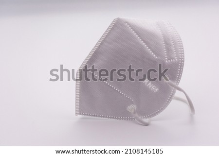 One KN-95 protection medical mask isolated on white background. Prevention of the spread of virus and epidemic, protective mouth filter mask. Diseases, flu, air pollution, coronavirus concept Royalty-Free Stock Photo #2108145185